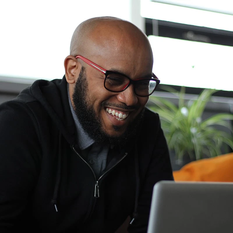 Marlon laughing while looking at something funny on his laptop